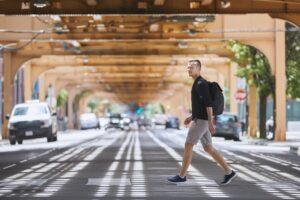 Man walking across a street and wondering if pedestrians always have the right of way in NY