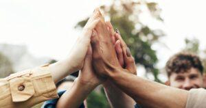 Hands, students and high five for teamwork outdoor with education support, learning and study success.
