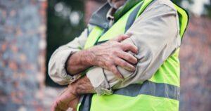 A construction worker clutching his elbow. Learn about how much compensation you can get for a work injury in New York.