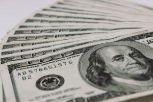 Stack of $100 bills. Learn what "no fee unless we win" means when you hire an injury law firm in New York.