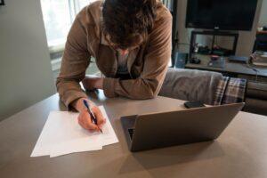 A man fills out a No-Fault application form at his desk after a car crash in New York.