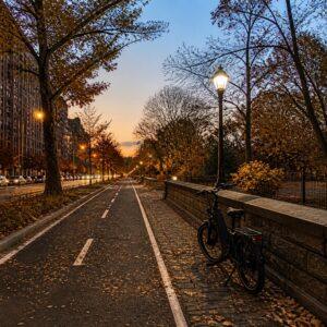 Empty bike lane along Central Park North in Harlem at dusk with a parked e-bike