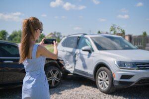 Driver documenting a hit and run incident in Nassau County after a car crash.